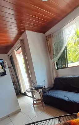 a living room with a couch and a table with a laptop at Zonte Rooftop Studio Apartment w Terrace-AC-Wif-BBQ in El Zonte