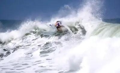 a man riding a wave on a surfboard in the ocean at Zonte Rooftop Studio Apartment w Terrace-AC-Wif-BBQ in El Zonte