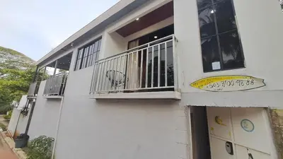 a white building with a balcony with a dog on it at Zonte Rooftop Studio Apartment w Terrace-AC-Wif-BBQ in El Zonte