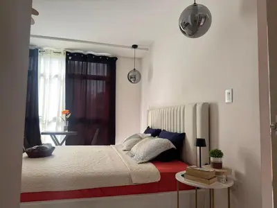 a bedroom with a bed with a red and white bedspread at Dormitorio privado con tu propio baño El apartamento la cocina y las áreas comunes son compartidas in San Salvador