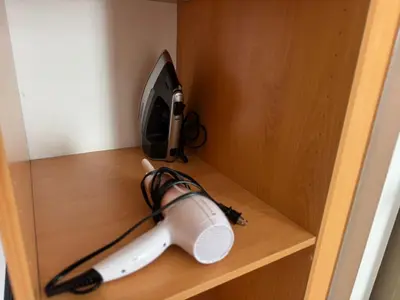 a hair dryer on a shelf in a cabinet at Dormitorio privado con tu propio baño El apartamento la cocina y las áreas comunes son compartidas in San Salvador