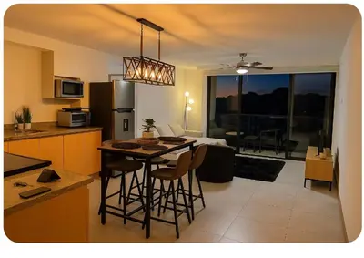 a kitchen with a table and some chairs in a room at Dormitorio privado con tu propio baño El apartamento la cocina y las áreas comunes son compartidas in San Salvador