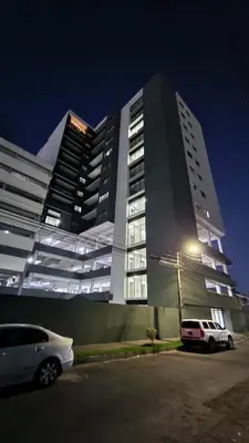 a white car parked in front of a large building at Luxury Apartment in San Salvador in San Salvador