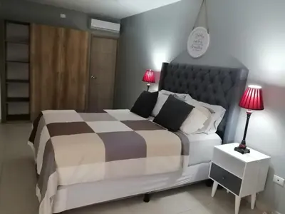 a bedroom with a large bed with two lamps on a table at Luxury Apartment in San Salvador in San Salvador