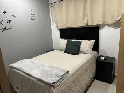 a small bedroom with a bed with a black headboard at Luxury Apartment in San Salvador in San Salvador