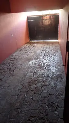 an empty room with a garage door and a stone floor at Casa San Fernando, Ahuachapan in Ahuachapán