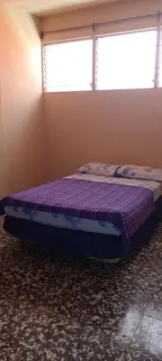 a bedroom with a purple bed in a room with a window at Casa San Fernando, Ahuachapan in Ahuachapán