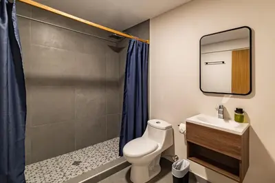 a bathroom with a toilet and a shower at Lora Loca Inn in El Zonte