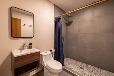 a bathroom with a toilet and a sink and a shower at Lora Loca Inn in El Zonte