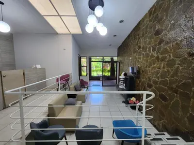 a living room with a stone wall and a staircase at Mochila Urban1 in San Salvador