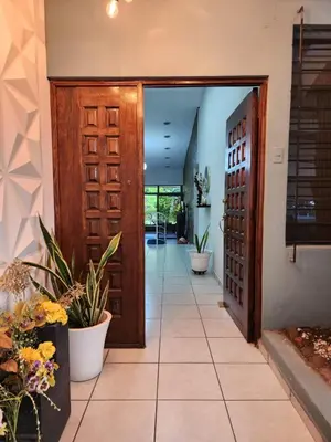 a hallway with a wooden door and some plants at Mochila Urban1 in San Salvador