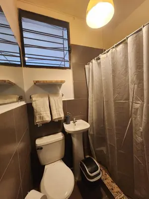 a bathroom with a toilet and a sink at La Mochila Urbana2 in San Salvador