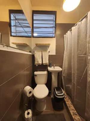 a bathroom with a toilet and a sink at La Mochila Urbana2 in San Salvador