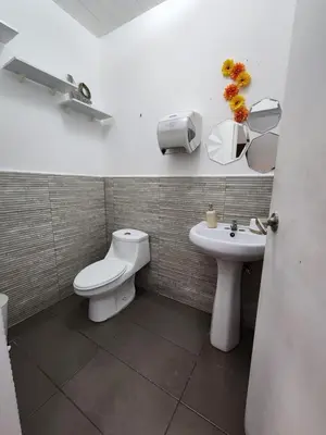 a bathroom with a toilet and a sink at La Mochila Urbana2 in San Salvador