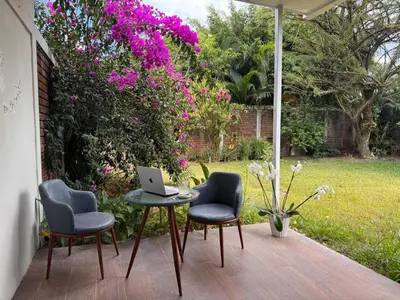 a patio with a table and two chairs and a laptop at La Mochila Urbana2 in San Salvador