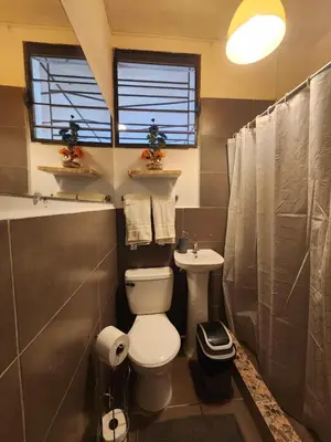 a bathroom with a toilet and a sink at La Mochila Urbana3 in San Salvador