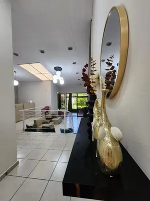 a lobby with a mirror and vases on a table at La Mochila Urbana4 in San Salvador