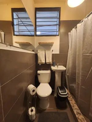a small bathroom with a toilet and a sink at La Mochila Urbana4 in San Salvador