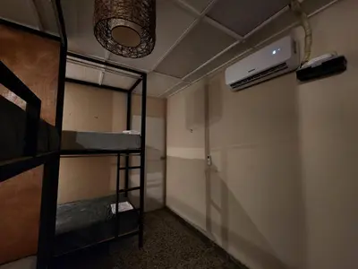 a room with bunk beds and a ceiling fan at La Mochila Urbana4 in San Salvador