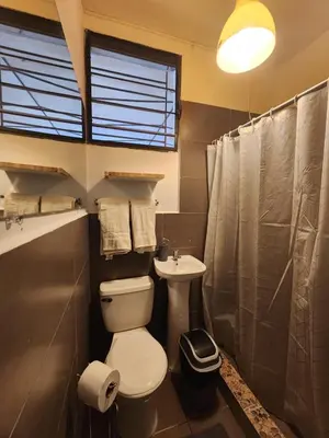 a bathroom with a toilet and a sink at La Mochila Urbana4 in San Salvador