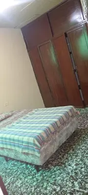 a bed in a bedroom with a wooden cabinet at San Fernando, Ahuachapan in Ahuachapán