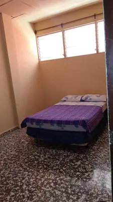 a bedroom with a purple bed in a room with a window at San Fernando, Ahuachapan in Ahuachapán
