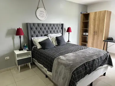 a bedroom with a large bed and a clock on the wall at Luxury Apartment -The Flats in San Salvador