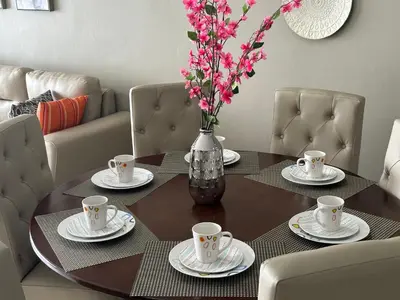 a dining room table with a vase with flowers on it at Luxury Apartment -The Flats in San Salvador