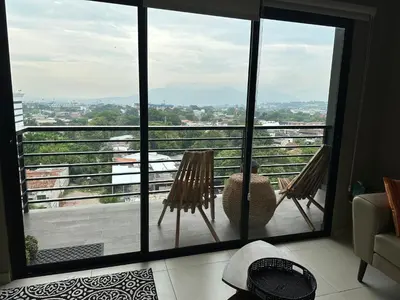a balcony with two chairs and a view of a city at Luxury Apartment -The Flats in San Salvador