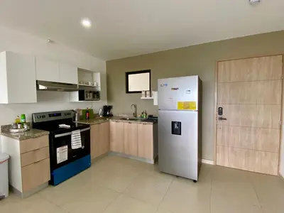a kitchen with a white refrigerator and a stove at Luxury Apartment -The Flats in San Salvador