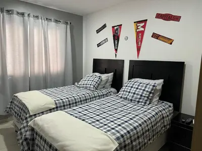 two beds in a bedroom with flags on the wall at Luxury Apartment -The Flats in San Salvador