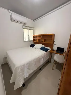 a bedroom with a bed and a desk with a laptop at Maadi-Tiny House-Los Ausoles in Ahuachapán