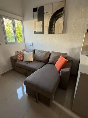 a living room with a gray couch and orange pillows at Maadi-Tiny House-Los Ausoles in Ahuachapán