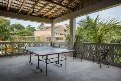 a ping pong table on a balcony with chairs at 2 Bedroom Apartment with full beds and bunk beds in El Zonte