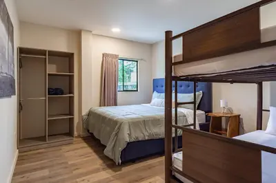 a bedroom with two bunk beds and a closet at 2 Bedroom Apartment with full beds and bunk beds in El Zonte