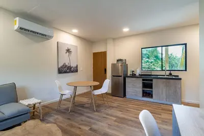 a living room with a table and a refrigerator at 2 Bedroom Apartment with full beds and bunk beds in El Zonte