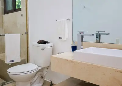 a bathroom with a white toilet and a sink at Then open space allowed for us to enjoy a big gathering in El Zapote