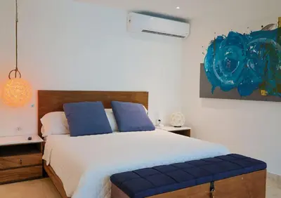 a bedroom with a large bed with blue pillows at Then open space allowed for us to enjoy a big gathering in El Zapote