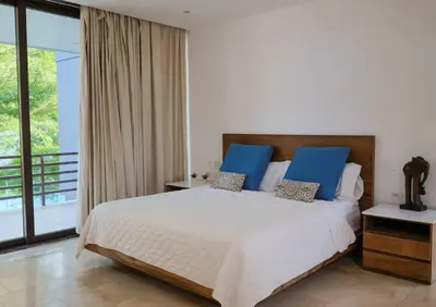 a bedroom with a large bed with blue pillows at Then open space allowed for us to enjoy a big gathering in El Zapote