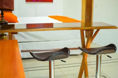 a table with two chairs in front of a bed at Suite 607 Ciudad jardín San Miguel A in San Miguel