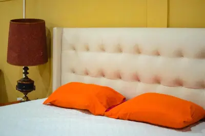 a bed with two orange pillows and a lamp at Suite 607 Ciudad jardín San Miguel A in San Miguel