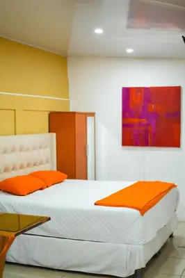 a bedroom with a bed with orange pillows and a painting at Suite 607 Ciudad jardín San Miguel A in San Miguel