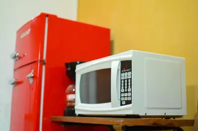 a microwave sitting on a table next to a red refrigerator at Suite 607 Ciudad jardín San Miguel A in San Miguel