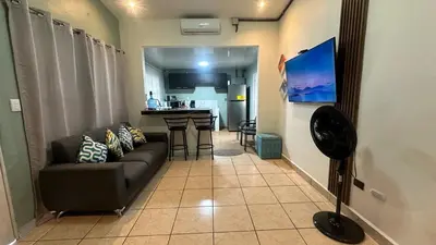a living room with a couch and a kitchen at Cerca de todo en La Union in La Unión