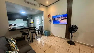 a living room with a couch and a kitchen at Cerca de todo en La Union in La Unión