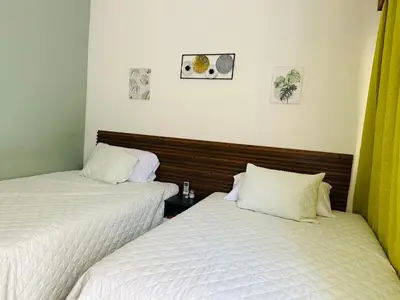 two beds sitting next to each other in a room at Cerca de todo en La Union in La Unión