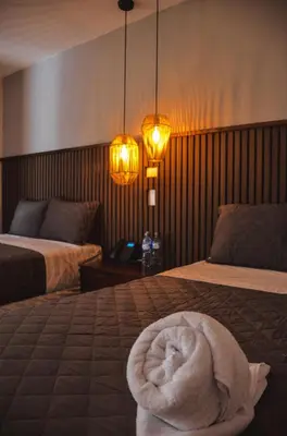 a room with two beds with a towel on the bed at Astra Beach Club & Resort in Marcelino