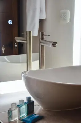 a bathroom with a white sink and a mirror at Astra Beach Club & Resort in Marcelino