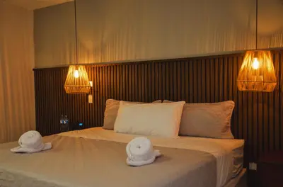 a bedroom with a bed with two hats on it at Astra Beach Club & Resort in Marcelino