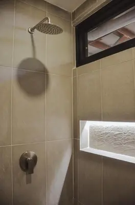 a shower with a shower head in a bathroom at Astra Beach Club & Resort in Marcelino